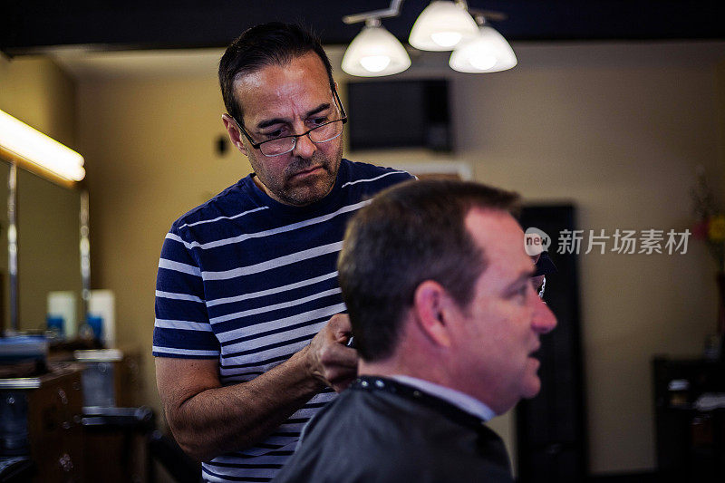 理发师/发型师修剪中年男子的头发